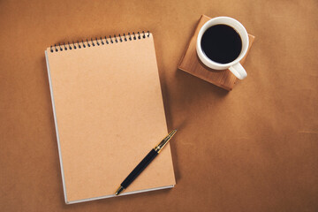 pen on notepad with coffee on table