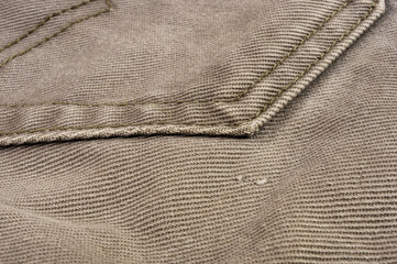 clothing items stonewashed cotton fabric texture with seams, clasps, buttons and rivets, macro