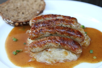 3 Nuremberg sausages on sauerkraut, served with sourdough bread and gravy