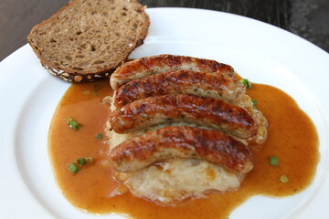 3 Nuremberg sausages on sauerkraut, served with sourdough bread and gravy