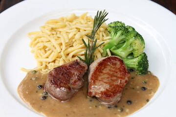 Pork medallions with broccoli and Spätzle on green pepper sauce