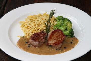 Pork medallions with broccoli and Spätzle on green pepper sauce
