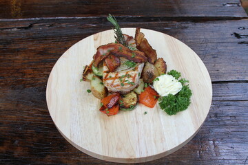 Pork steak with crispy bacon, served on grilled vegetables and horseradish cream