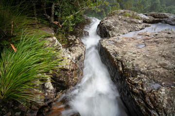 Water cascades through the rocks before it plunges down a rock face.
