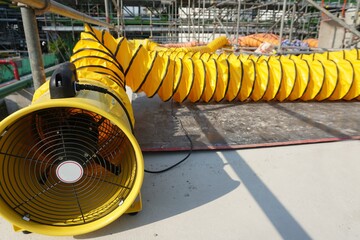 Flexible air duct for ventilation from confined spaces in the construction of large chemical storage tanks.