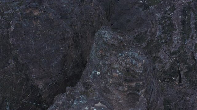 A rock formation in the valley of The Lost City, Lithgow, Australia. A barren landscape covered in rock and moss.