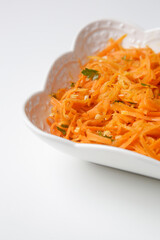 Simple carrot salad in a bowl, fresh and healthy vegetarian meal with parsley and garlic dressing