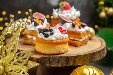 front view delicious cream cakes around new year tree toys on dark background dessert cake sweet photo cream