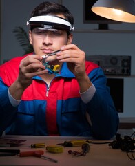 Computer specialist repairing PC late at night