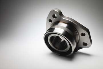 New wheel bearing in a metal housing on a black-white gradient background. New car suspension parts