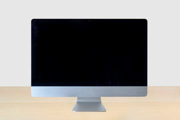 Front view of a computer on a wooden table with a white background