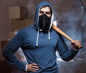 Hooligan with bat in dark room