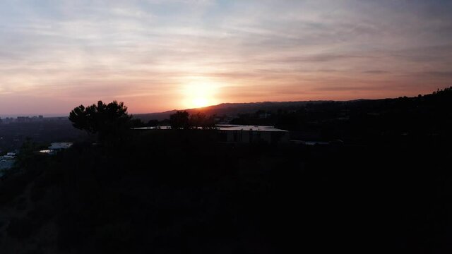 Rising aerial shot of Beverly Hills hillside during sunset. 4K