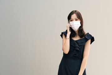 Asian women using smartphone with medical face mask to protect the Covid-19, new normal lifestyle
