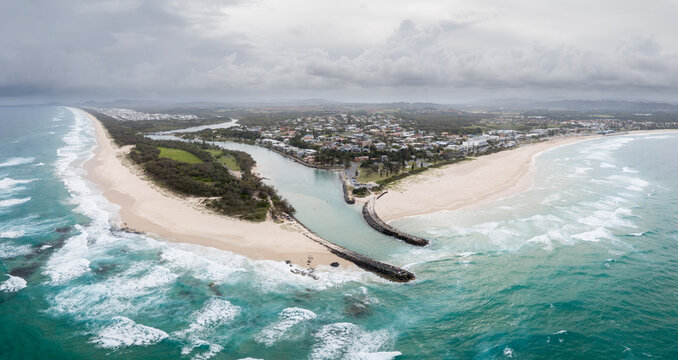 Kingscliff, NSW with Cudgen Creek aerial image with storm rolling in and blue water overlooking creek mouth and Kingscliff town and beach