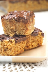 A close up of three rice krispie treats on a plate.