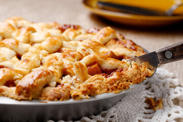 Cutting into a delicious home baked apple pie on the table.