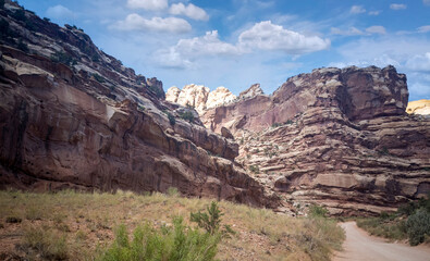 Unbelievable sandstone cliff and superlative domes with tumbleweeds on a hot summer partly cloudy day in Capitol Reef National Park in Southern Utah