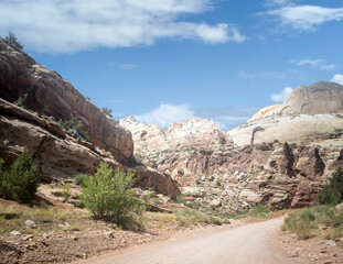 Unbelievable sandstone cliff and superlative domes with tumbleweeds on a hot summer partly cloudy day in Capitol Reef National Park in Southern Utah
