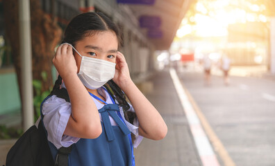 Back to school. asian child girl wearing face mask with backpack going to school .Covid-19 coronavirus pandemic.New normal lifestyle.Education concept..