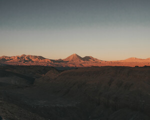 Naklejka premium View of the mountains and a vulcano in the desert during sunset