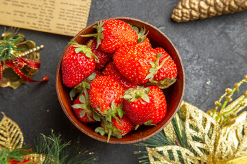 top view fresh strawberries inside plate around christmas toys on dark background photo mellow many fruit color