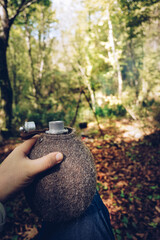 Man in bushcraft with a flask in hand
