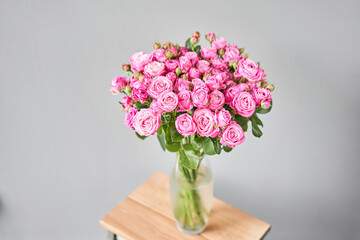 pink rose branch in a vase . Summer background. Bouquet of roses present for Mothers Day. Photo of Flowers for a catalog of flower online store and delivery.