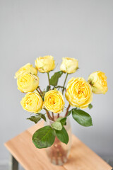 Yellow rose in a vase . Summer background. Bouquet of roses present for Mothers Day. Photo of Flowers for a catalog of flower online store and delivery.