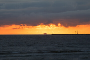 Dramatic sunset sky over the sea and the pier.