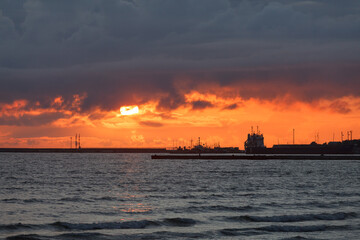 Dramatic sunset sky over the sea and the pier.