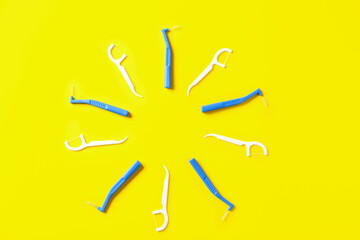Frame made of toothbrushes for dental braces and floss on color background