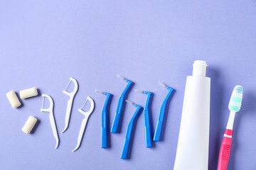 Toothbrushes for dental braces, floss and paste on color background