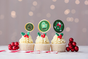Tasty Christmas cupcakes on blurred background