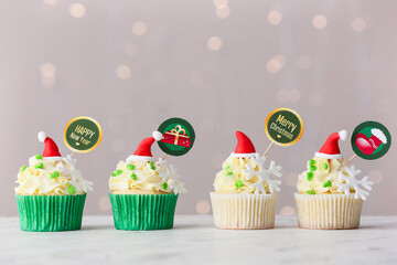 Tasty Christmas cupcakes on blurred background