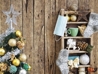 Coronavirus medical protective mask with Christmas decor on an old shelf on a wooden background. Protect yourself from the virus.
