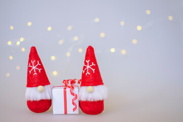 Christmas gnomes with a gift. Blurry lights. Christmas. New Year. Delivery of the gift. To deliver gifts. Copy space