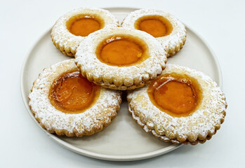 Round cookies with fruit jam and icing sugar, italian occhi di bue, isolated on white background. 