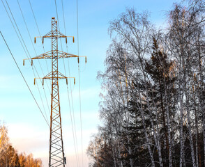 Metal support for high voltage power lines against the sky. Electrical cables are attached to the...