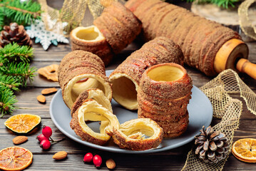 Trdelnik is a baked delicacy on a spit and charcoal dough with sugar, cinnamon and vanilla. Christmas sweets, street food. Czech and Moravian cuisine.