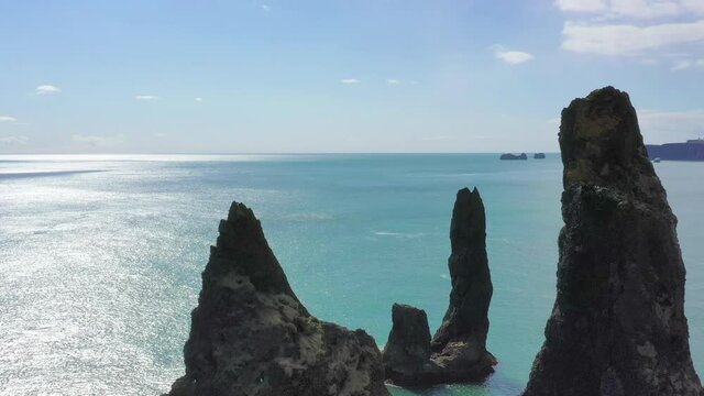 High definition drone aerial video flying over volcanic rock formations along  Atlantic Ocean Coastline near Vik, Iceland.