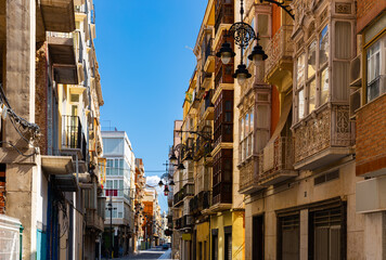 Fototapeta na wymiar Picturesque architecture of typical narrow street in historic center of Spanish city of Cartagena on summer day