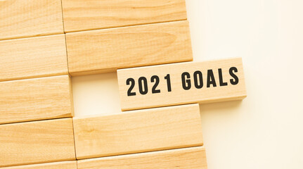 2021 GOALS text on a strip of wood lying on a white table.