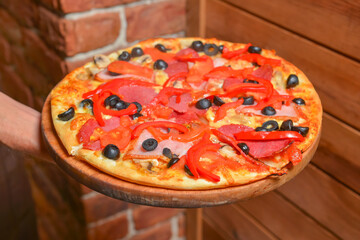 Waiter serving pizza in restaurant. Restaurant service, waiter at work, eating out concept.