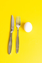 Fork and spoon with white egg. Breakfast concept  