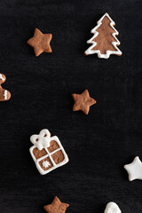 Gift box and stars from gingerbread on black background. Traditional pastries. Vertical frame