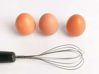 A chicken egg with egg beater isolated on white background.