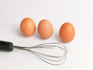 A chicken egg with egg beater isolated on white background.