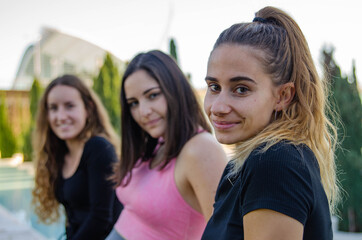 Close-up of Three  Young Women Friends in Sporty Tracksuit Looking at Camera in a Park