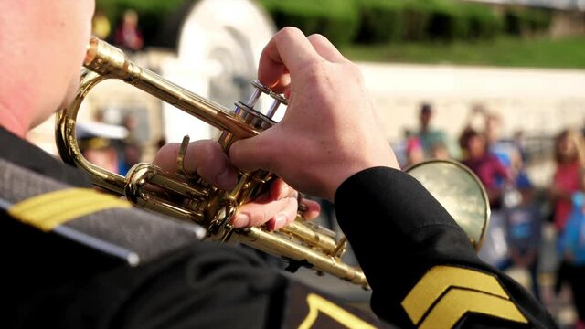 A wind instrument - a unrecognizable military man is playing trumpet, close-up. High quality 4k footage